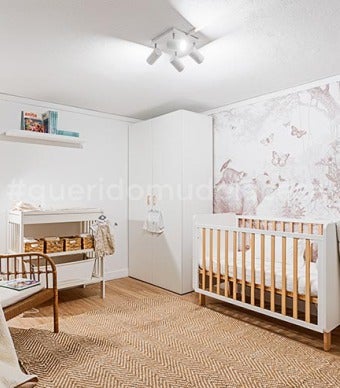 Quarto de bebé com dois roupeiros e o berço no meio. papel de parede com desenho castanhos e uma cadeira de verga